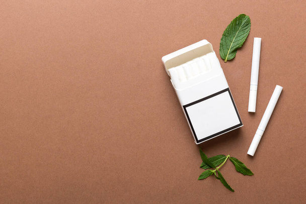 Bir paket mentollü sigara ve renkli masada taze nane şekeri, mentollü sigaralar düz yerde yatıyordu.. - Fotoğraf, Görsel
