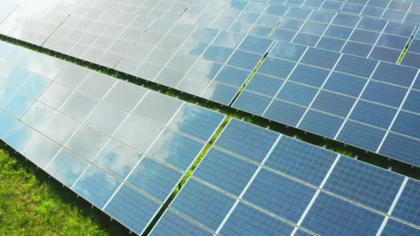 Painéis solares refletem nuvens brancas na superfície construída no campo rural. Células solares fotovoltaicas modernas geram energia renovável na estação elétrica - Filmagem, Vídeo