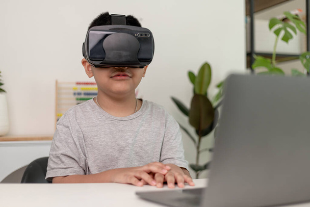 Азиатский мальчик в очках VR изучает науки дома, любопытный студент носит гарнитуру виртуальной реальности, чтобы изучать науку дома онлайн исследование футуристического образа жизни - Фото, изображение