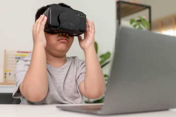 VR gözlüklü, evde fen bilgisi okuyan Asyalı küçük çocuk, meraklı öğrenci evde fen bilgisi öğrenmek için sanal gerçeklik kulaklığı takıyor. - Fotoğraf, Görsel
