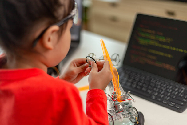 Ázsia diákok megtanulják otthon kódolás robot autók és elektronikus tábla kábelek STEM, STEAM, matematika mérnöki tudományok számítógépes kód robotika gyerekeknek koncepció. - Fotó, kép