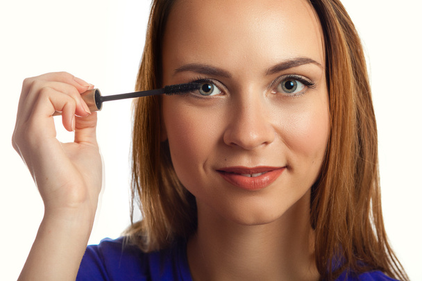 Young Woman putting mascara makeup - Foto, Imagen