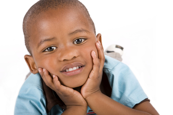 Suloinen 3-vuotias musta tai afrikkalainen amerikkalainen poika makaa kädet leualla
 - Valokuva, kuva
