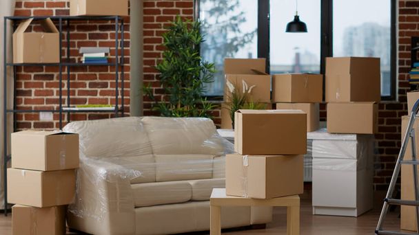 No people in empty real estate apartment with moving boxes and cardboard storage containers. Nobody in household property filled with packages and furniture for relocation decor. - Photo, Image