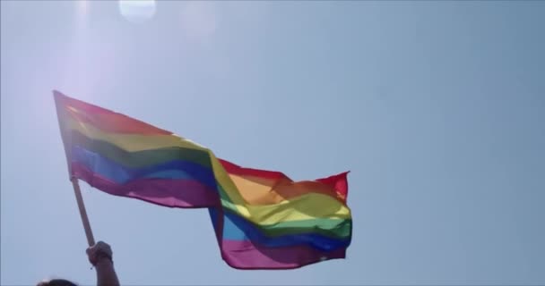LMBT meleg büszkeség szivárvány zászló lengett a büszkeség ünneplés, Az emberek egy szivárvány zászló tánc és lengetni a zászlót az éves meleg büszkeség felvonulás, Színes háttérvilágítású szivárvány zászló meleg büszkeség vagy LMBT. - Felvétel, videó