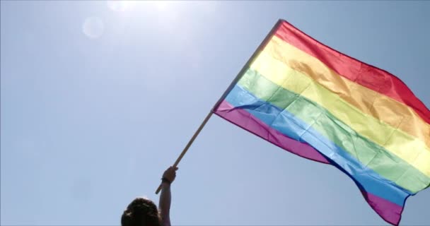 LMBT meleg büszkeség szivárvány zászló lengett a büszkeség ünneplés, Az emberek egy szivárvány zászló tánc és lengetni a zászlót az éves meleg büszkeség felvonulás, Színes háttérvilágítású szivárvány zászló meleg büszkeség vagy LMBT. - Felvétel, videó