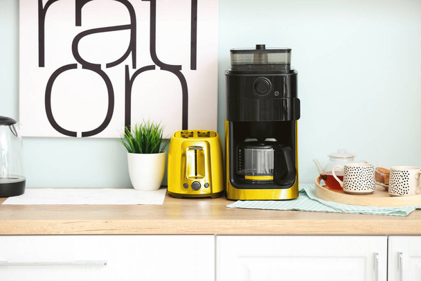 Modern coffee machine and toaster on table in kitchen - 写真・画像