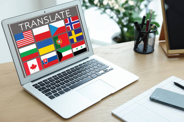 Workplace with laptop and images of different flags on screen, phone, stationery in office - Fotoğraf, Görsel