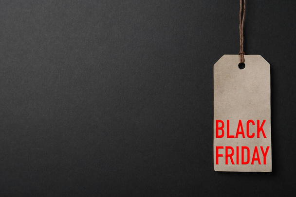 LIght grey tag with phrase BLACK FRIDAY on dark background, top view. Space for text - Photo, Image