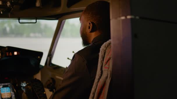 Portret afrykańskiego pilota siedzącego w samolocie z kapitanem, gotowego do lotu samolotem z deską rozdzielczą panelu sterowania. Dowództwo nawigacyjne z silnikiem w kabinie. Strzał ręczny. - Materiał filmowy, wideo