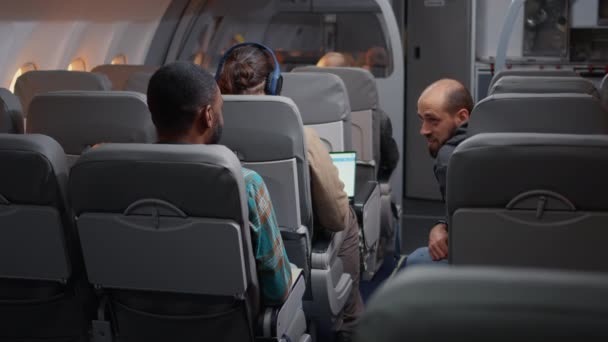 Bir grup turist uçak yolculuğu için uçağa biniyor ve havalanmadan önce sohbet ediyorlar. Uçak koltuklarında taşımacılık ve ticari havayolları hakkında konuşmak, ekonomi sınıfında uçmak.. - Video, Çekim