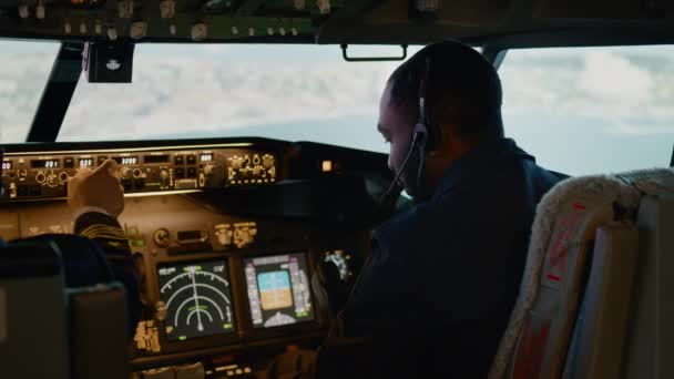 Африканський американський пілот літає з капітаном у кабіні, з ручкою двигуна і фіксацією висоти і довготи. Команда навігації на панелі приладів і панелі керування. Ручний постріл.. - Кадри, відео