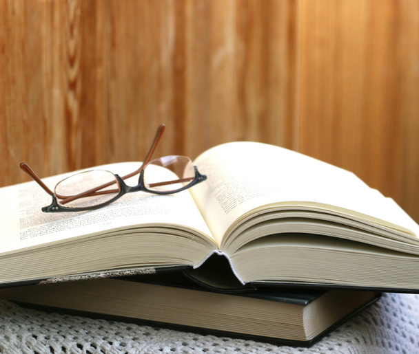 Товста відкрита книга і окуляри на ній
 - Фото, зображення