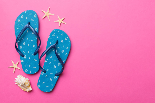 Flat lay composition with flip flops and seashell on colored background. Space for text top view. - Foto, Imagem