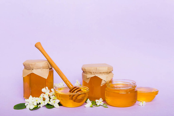 robinia honing bollte met acacia bloesems op gekleurde tafel. - Foto, afbeelding
