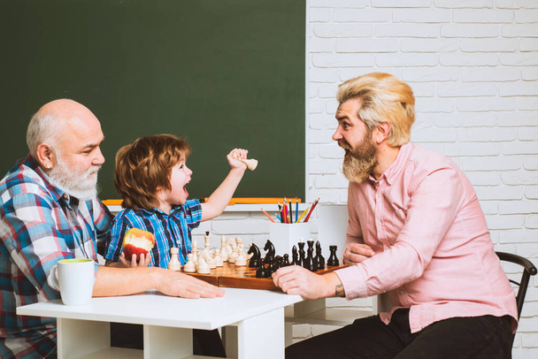 Fathers day. Father and son with grandfather playing chess. Men generation - Photo, image