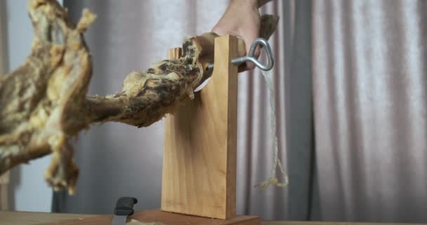 A mans hand, screwing an empty leg of jamon to the stand. Close-up. The concept of wise use of resources, you need to finish eating, the bone of the pig leg. High quality 4k footage - Séquence, vidéo