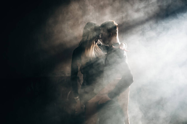 Couple of two professional ballroom dancers is dancing on loft studio. Beautiful art performance with heavy smoke. Sport life concept. Passion and emotional dance. - Foto, immagini