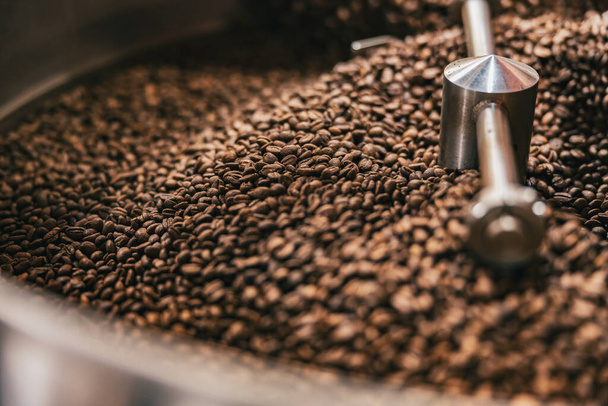 Close up de grãos de café na máquina de torrefação de café em uma pequena fabricação. Foto de alta qualidade - Foto, Imagem