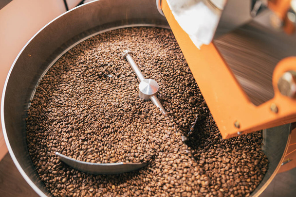 Close up de máquina de torrefação de café com grãos na fabricação de café pequeno. Foto de alta qualidade - Foto, Imagem