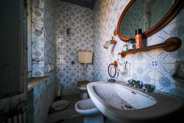 санузел с раковиной и полотенцами в заброшенном доме. Высокое качество фото - Фото, изображение
