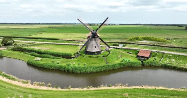 Históricos tradicionales molinos de viento antiguos holandeses en el campo en la naturaleza verde campo de hierba paisaje de la granja con un clima soleado río. - Metraje, vídeo