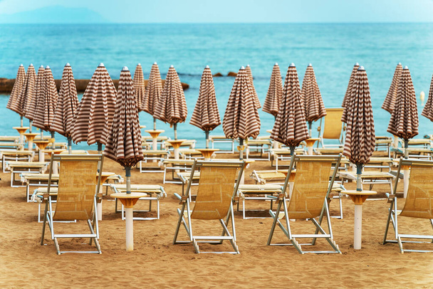Ξαπλώστρες και ομπρέλες στην ιδιωτική παραλία. - Φωτογραφία, εικόνα