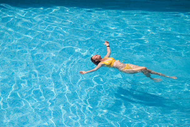 вид сверху женщины, плавающей в бассейне - Фото, изображение