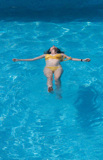 vista dall'alto della donna galleggiante in piscina - Foto, immagini