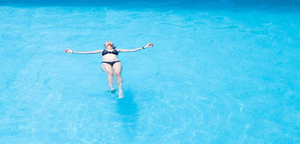 pohled shora na ženu plovoucí v bazénu - Fotografie, Obrázek