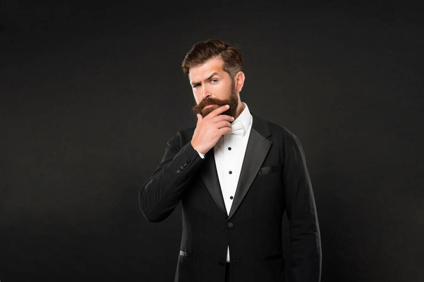 serious unshaven man in tuxedo bow tie. gentleman in formalwear on black background. male formal fashion. - Photo, image