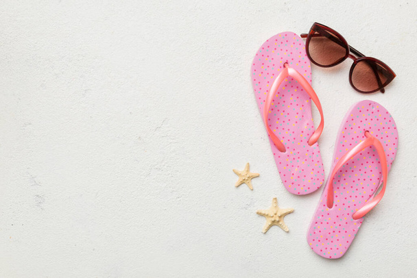 Summer travel concept. Flip flops, sunglasses and starfish on white. Top view on colored background. - Foto, Imagen