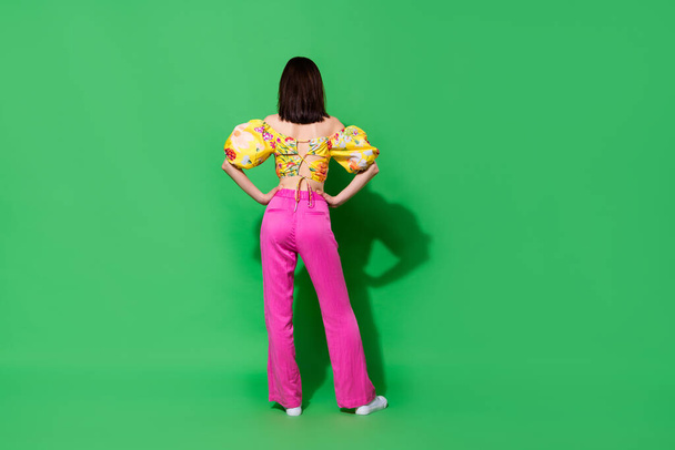 Full length photo of slim confident lady wear off shoulders blouse standing back hands arms waist isolated green color background. - Foto, Imagem