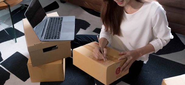 Shipping nakupování on-line, mladý start up malé firmy majitel psaní adresy na kartonové krabici na pracovišti. - Fotografie, Obrázek