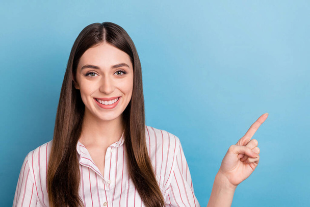 Portrait of attractive cheerful girl demonstrating copy space ad solution way isolated over vibrant blue color background. - Фото, изображение