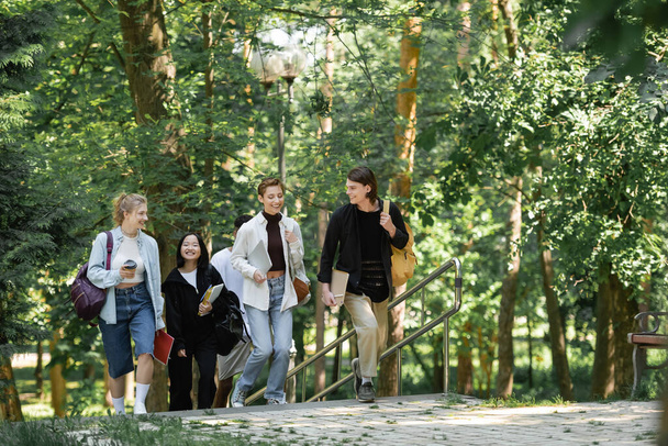 Pozitív diákok hátizsákkal séta barátokkal a parkban  - Fotó, kép