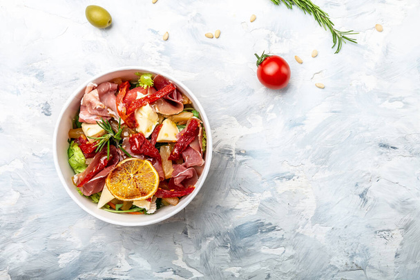 Healthy salad with Prosciutto, ham and grapefruit jamon, salad mix, grapefruit, cherry tomatoes, parmesan cheese. in plastic package for take away or food delivery. place for text, top view. - Photo, Image