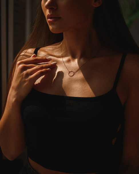 Attractive brunette with a cold pendant on chains around her neck. Precious gift. - Φωτογραφία, εικόνα