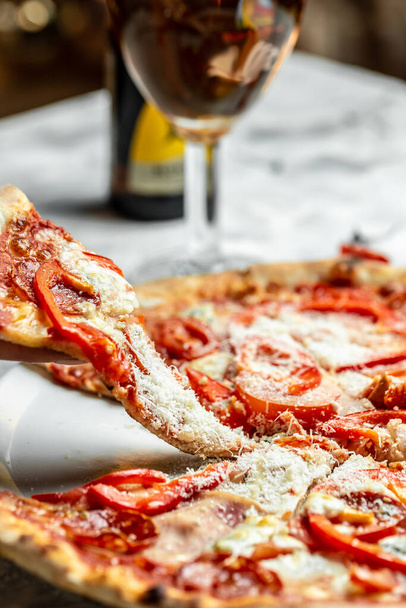 伝統的なイタリアのピザ、野菜、食材。ピザはオーブンで調理しています。光を背景にしたピザメニュー、トップビュー . - 写真・画像