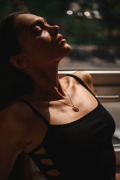 Attractive brunette with a cold pendant on chains around her neck. Precious gift. - Fotografie, Obrázek