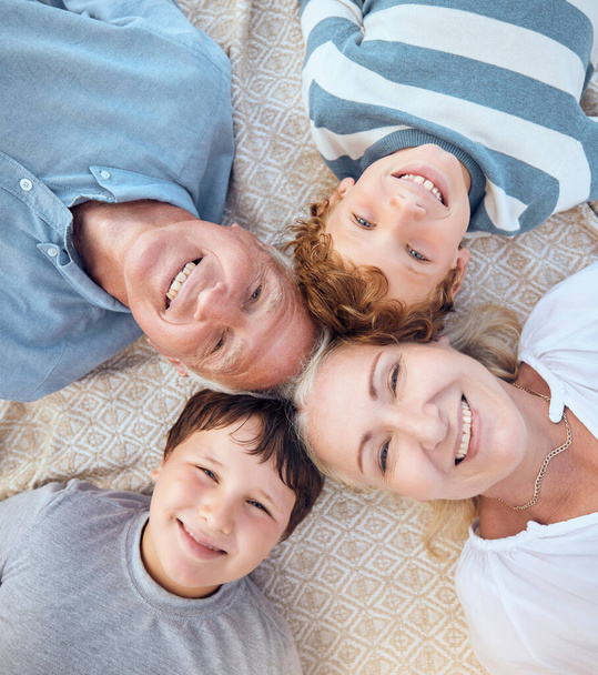 Happy caucasian grandparents lying with grandsons on a beach. Adorable, happy, children bonding with grandmother and grandfather in a garden or park outside. Family taking selfies together. - Фото, изображение