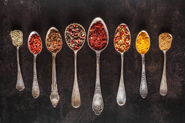 Various spices a vintage spoons on stone table. Colorful Herbal and Spices Oriental marketplace.Top view . Cafe concept. Delicious food delivery. - Foto, Imagem