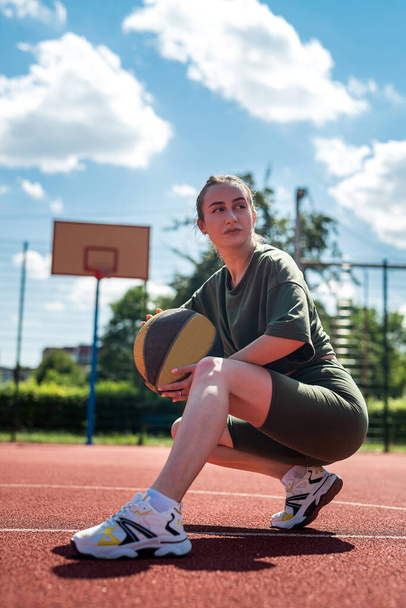 Sportliche junge Frau posiert mit Ball auf dem Platz. Das Konzept der Sportfotografie. Porträt eines Sportlers - Foto, Bild
