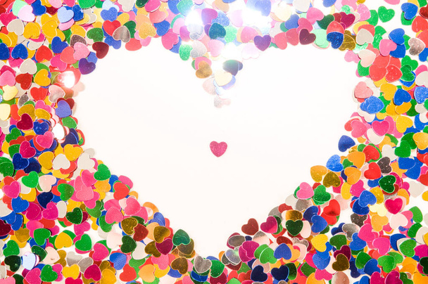 colorful background for valentine's day card, pieces of confetti laid out in the shape of a heart - Photo, image