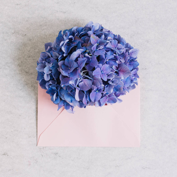 purple hydrangea flower pink envelope against rough backdrop - Photo, Image