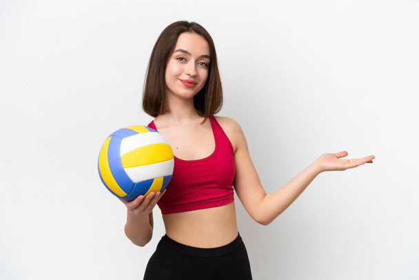 Fiatal ukrán nő játszik röplabda elszigetelt fehér háttér kiterjeszti kezét oldalra meghívó jönni - Fotó, kép