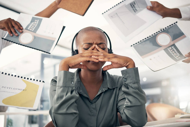 Anxious young african american call centre telemarketing agent feeling pressure and headache while working in demanding busy office environment. Overworked and exhausted consultant trying to multitask - Photo, image