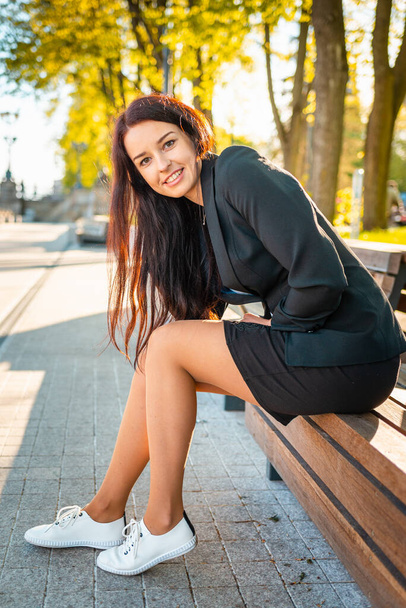 Beautiful and elegant smiling business woman sitting in a park.Summer sunset portrait of a charming caucasian lady. - Foto, immagini