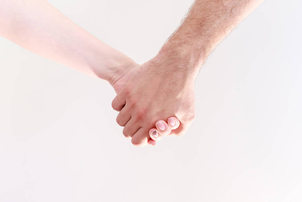 Mies pitää naisen kättä valkoisella pohjalla. Pari. uskollisuus - Valokuva, kuva