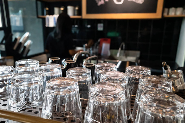 Rzędy czystych okularów w kawiarni z kelnerką na tle - Zdjęcie, obraz